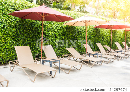 Umbrella chair around swimming pool 24297674