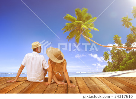 Couple Sitting on Wooden Floor at Beach 24317610