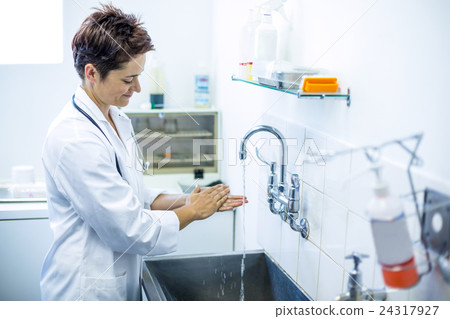 Woman vet smiling and washing her hands 24317927
