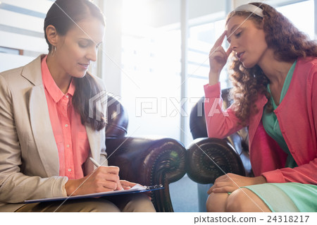 Beautiful young woman discussing with psychologist Beautiful young woman discussing with psychologist 24318217