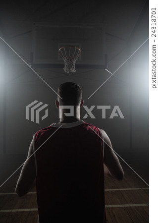 Portrait of basketball player front the back in front of a baske 24318701