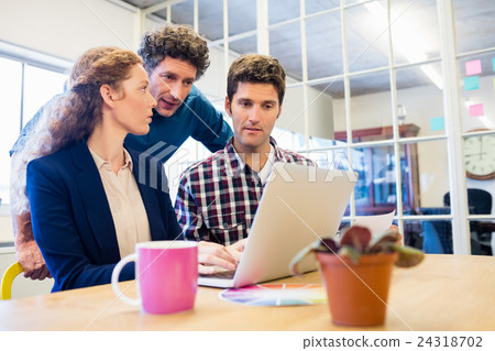 Businesspeople working and looking a laptop together 24318702