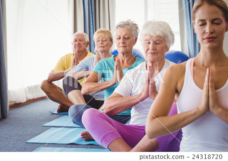 Front view of seniors relaxing with fitness instructor Front view of seniors relaxing with fitness instructor 24318720