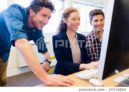 Businesspeople smiling and looking a computer Businesspeople smiling and looking a computer 24319864