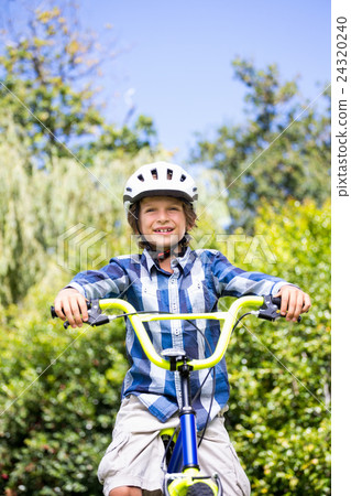 Portrait of cute boy smiling and posing on his bike Portrait of cute boy smiling and posing on his bike 24320240