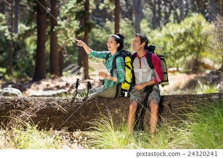 Couple pointing and sitting on a tree 24320241