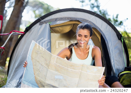 Woman smiling and studying a map Woman smiling and studying a map 24320247