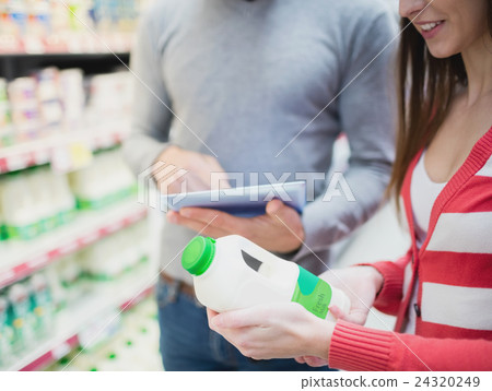 Close up view of couple doing grocery shopping together Close up view of couple doing grocery shopping together 24320249