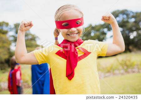 Portrait of young girl with superhero dress smiling and showing Portrait of young girl with superhero dress smiling and showing 24320435