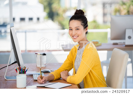 A woman is working at her desk 24320917