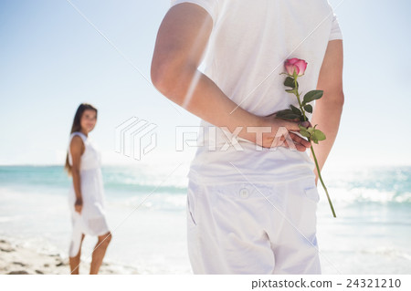Close up of man holding a rose behind him Close up of man holding a rose behind him 24321210