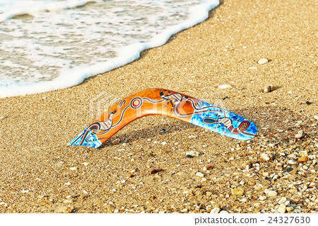 Colorful boomerang on sandy beach near sea surf. 24327630