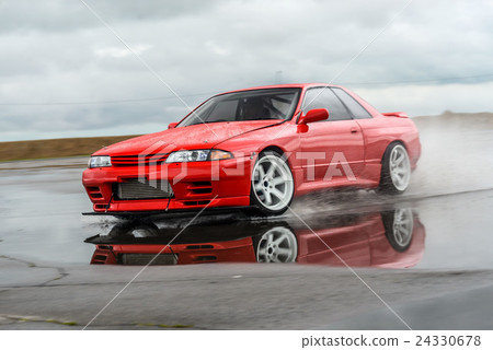 Nissan skyline R 32 red color on a wet road 24330678