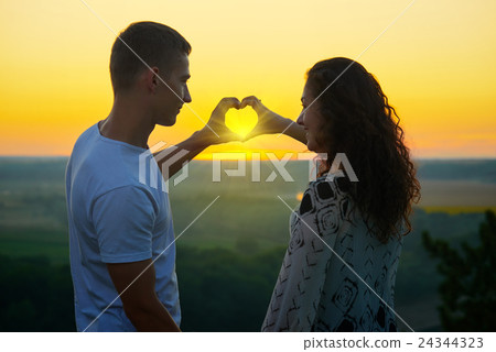 romantic couple at sunset make a heart from hand romantic couple at sunset make a heart from hand 24344323