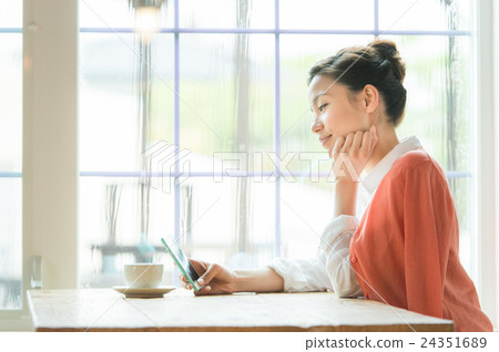 A woman with a smartphone (cafe window side) 24351689
