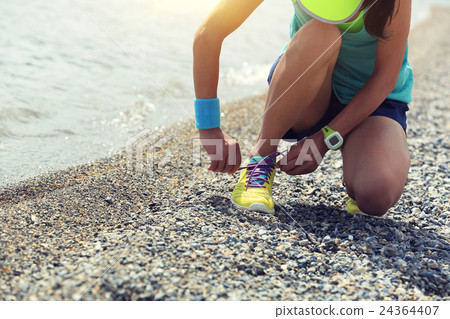 woman runner tying shoelace before running   24364407