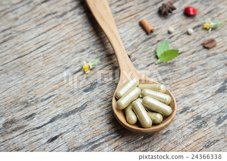 Herbal capsule on wooden spoon  24366338