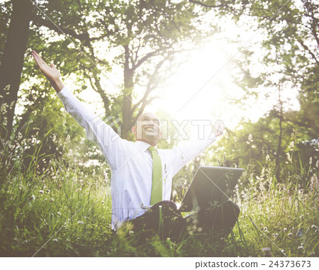 Businessman Sitting In a Forest With His Laptop Businessman Sitting In a Forest With His Laptop 24373673