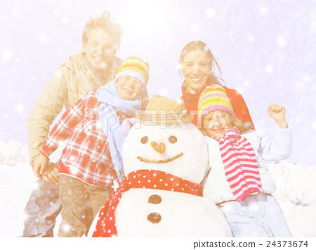 Family Posing With A Snowman Outdoors Family Posing With A Snowman Outdoors 24373674