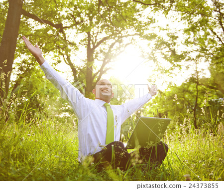 Businessman Sitting In a Forest With His Laptop Businessman Sitting In a Forest With His Laptop 24373855