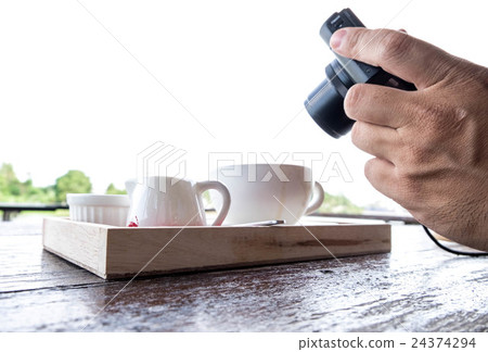 Man taking photo of coffee set. Handholding camera 24374294