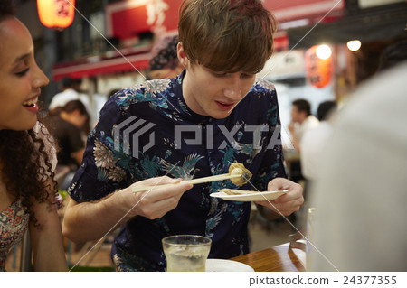 Foreign travelers enjoying Japanese food Foreign travelers enjoying Japanese food 24377355