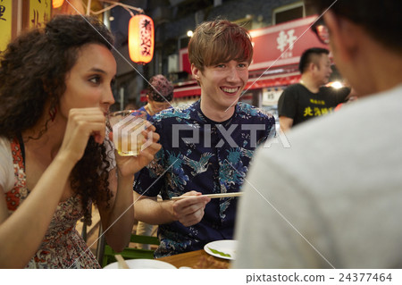 Foreign travelers enjoying Japanese food 24377464