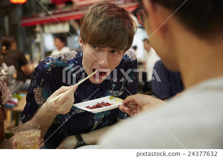 Foreign travelers enjoying Japanese food Foreign travelers enjoying Japanese food 24377632