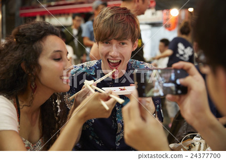 Foreign travelers enjoying Japanese food 24377700