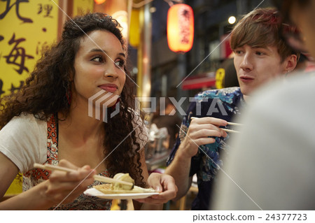Foreign travelers enjoying Japanese food Foreign travelers enjoying Japanese food 24377723