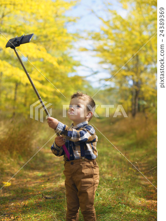 happy little boy taking selfie stick picture 24389369