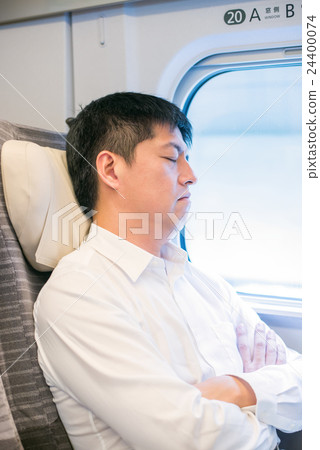 A man sleeping in the train of a bullet train 24400074