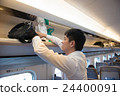 A man putting baggage in the train of a bullet train 24400091