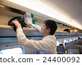 A man putting baggage in the train of a bullet train 24400092