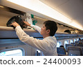 A man putting baggage in the train of a bullet train 24400093