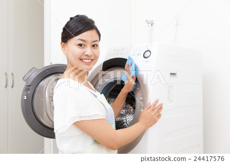 Housewife cleaning the washing machine Housewife cleaning the washing machine 24417576