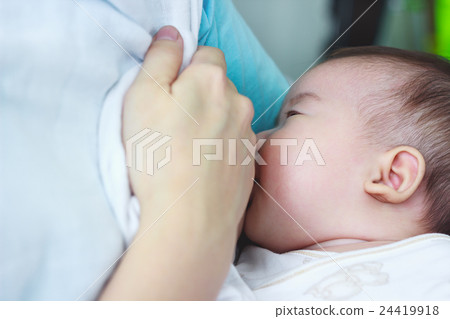 Closeup mother breastfeeding her baby with milk. 24419918