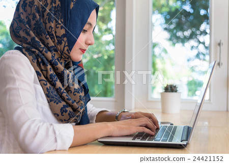 Muslim female working with computer in the room. 24421152