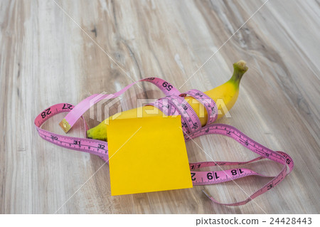 Banana with Sticky Note on wood table . Banana with Sticky Note on wood table . 24428443