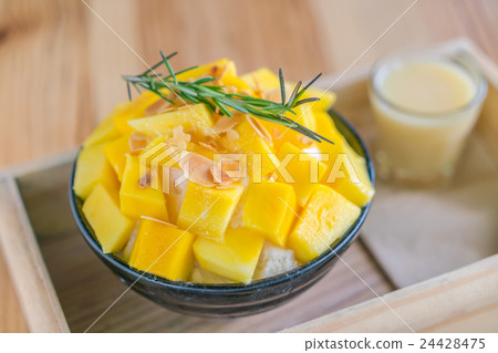 Korean style fresh mango shaved ice on wood table . 24428475