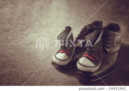 Daddy's boots and baby's sneakers, on wood 24431941