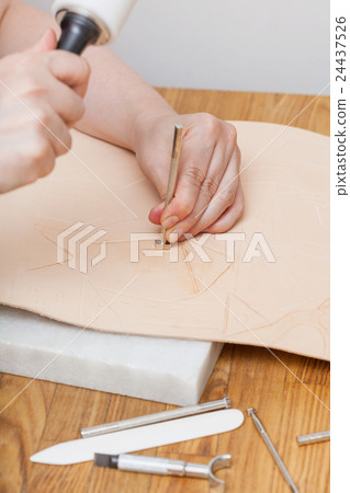 craftsman puts stamping on leather 24437526