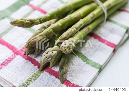 Bunch of fresh asparagus on kitchen cloth closeup 24440403