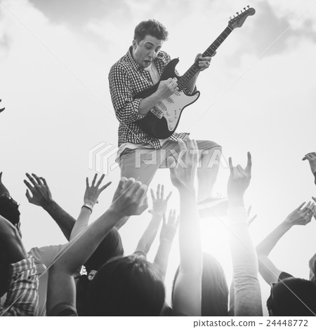 Young Man with a Guitar Performing on an Ecstatic Crowds 24448772
