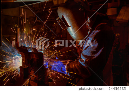 Welder is welding automotive part in factory 24456285
