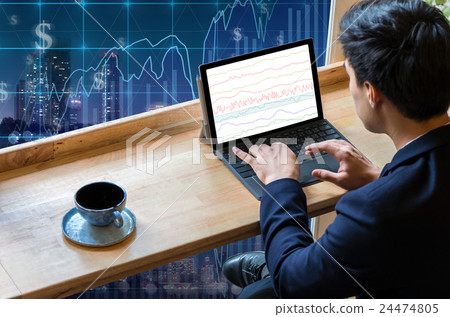 Businessman sitting and using computer laptop showing trading graph beside the windows glass over the Trading graph on the cityscape background, Business financial concept Businessman sitting and using computer laptop showing trading graph beside the windows glass over the Trading graph on the cityscape background, Business financial concept 24474805