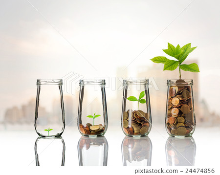 Gold coins and seed in clear bottle on cityscape photo blurred cityscape background,Business investment growth concept Gold coins and seed in clear bottle on cityscape photo blurred cityscape background,Business investment growth concept 24474856