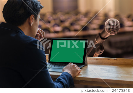 Businessman sitting and using computer laptop showing the blank green screen over the Microphone on the Abstract blurred photo of conference hall or seminar room background, Business meeting concept Businessman sitting and using computer laptop showing the blank green screen over the Microphone on the Abstract blurred photo of conference hall or seminar room background, Business meeting concept 24475848