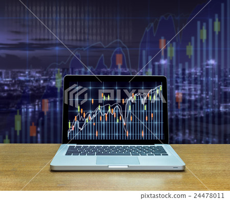 Stock exchange market trading graph over the screen of computer laptop on wood table over the photo blurred of trading graph background, business marketing trade concept 24478011