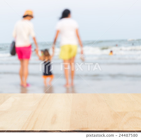 Wood with blurred family take care baby on beach. 24487580